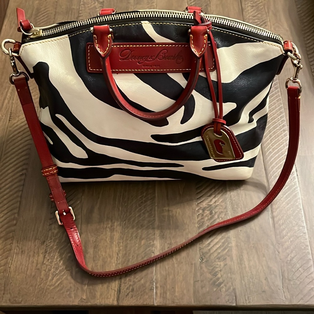 Large Dooney and Bourne satchel. White and black zebra print with red handles.